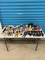 Wide shot of entire lot on table showing variety of tools and hardware