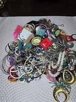 Pile of mixed jewelry showing variety of items and materials