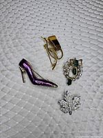 Front view of four brooches displaying designs and stones