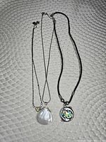 Three necklaces laid out showing full length and pendants