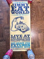 Full view of vertical Jimmy Eat World concert poster on wood floor