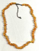 Full view of orange stone chip necklace laid flat