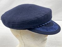 Side view of navy fisherman cap showing overall shape and visor details