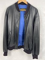 Full front view of black leather bomber jacket with blue lining visible