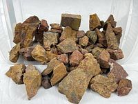 Bin filled with numerous rough yellow and red jasper stones
