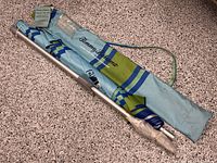 Umbrella pole, folded canopy and carry bag showing overall set