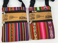 Two colourful Peru souvenir shoulder satchels showing woven fabric, zippers and patch