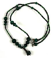 Full view of beaded necklace showing bird claw pendant, bead pattern, and clasp