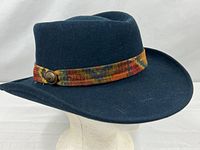 Side profile of dark navy wool hat showing patterned band and button detail