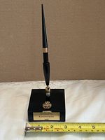 Full view of desk pen on base with measuring tape along base