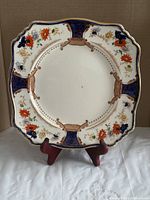Full view of square dinner plate on stand