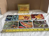 All six coasters with presentation box and tape measure for scale