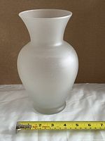Front view of frosted glass vase with tape measure showing width