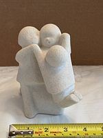 Front view of sculpture next to tape measure showing scale