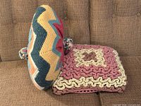 Both crocheted pillows on couch