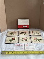 six coasters, box, leaflet, tape measure showing size