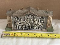 Front view showing relief scene and measuring tape for scale