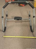 Front view of abdominal rocker showing frame, grips, headrest