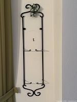 Full view of black metal plate holder on wall