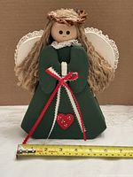 Front view of wooden angel with measuring tape for width