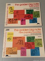 Both sheet music books laid out together showing full covers