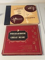 Closed album covers of both record sets