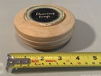 Closed dish beside tape for diameter measurement