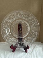 Full view of clear pressed glass plate on stand
