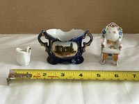 Front view of all three miniature bone china pieces with tape measure for scale