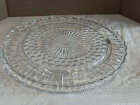 Top view showing entire clear glass footed cake plate with decorative pattern