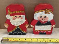 Front view of both wooden figures with tape measure for width