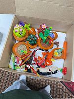 Overview of box showing potted plant builds, loose LEGO pieces and screwdriver