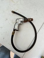 Full view of Central Pneumatic air drill with attached hose