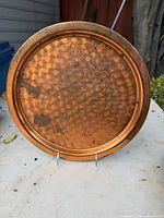 Front view of round hammered copper serving tray with patina