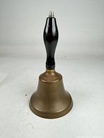 Full view of brass hand bell standing upright