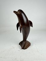 Front view of carved rosewood dolphin on block base