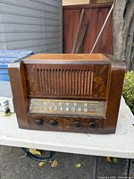 Front view of RCA Victor wood tabletop radio showing grille, dial and knobs
