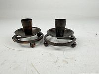 Two matching metal candlestick holders front view