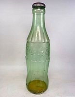 Full view of glass Coca-Cola piggy bank standing upright
