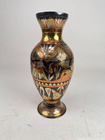 Front view of brass vase showing Egyptian motifs