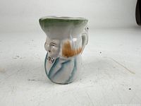 Left side view showing figural form and hand painted details