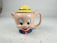 Front view of Porky Pig mug with hat lid