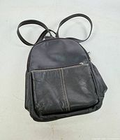 Front view showing overall shape, front zip pocket, leather texture