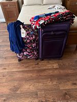 Two softside spinner suitcases, cardigan, blanket and accessory displayed together