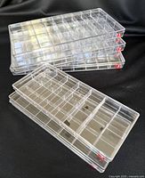 Stack of clear acrylic trays showing compartments