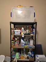 Full shelving unit with clear plastic bin and assorted cleaners