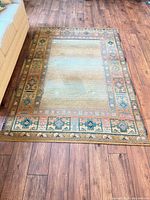 Full view of rug on hardwood floor showing colour and design