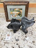 Framed print and resin fish sculpture together on countertop