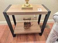 full view of two-tier end table showing wood shelves and black metal frame
