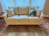 Front view of La-Z-Boy cream 3-seater sofa with three throw pillows